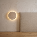 Atelierée Oro travertine wall light, warm downward glow