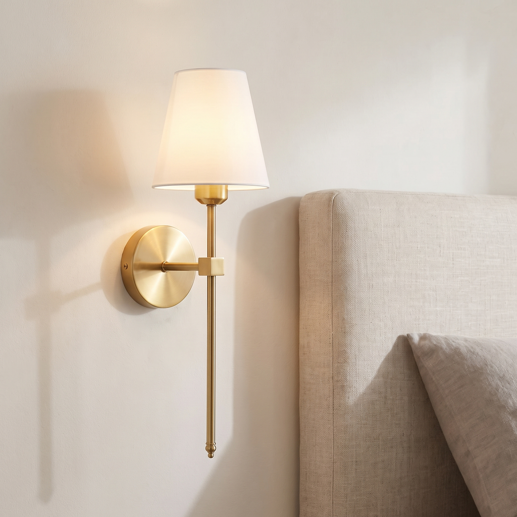 Atelierée Halston rechargeable brass wall light mounted beside a bed