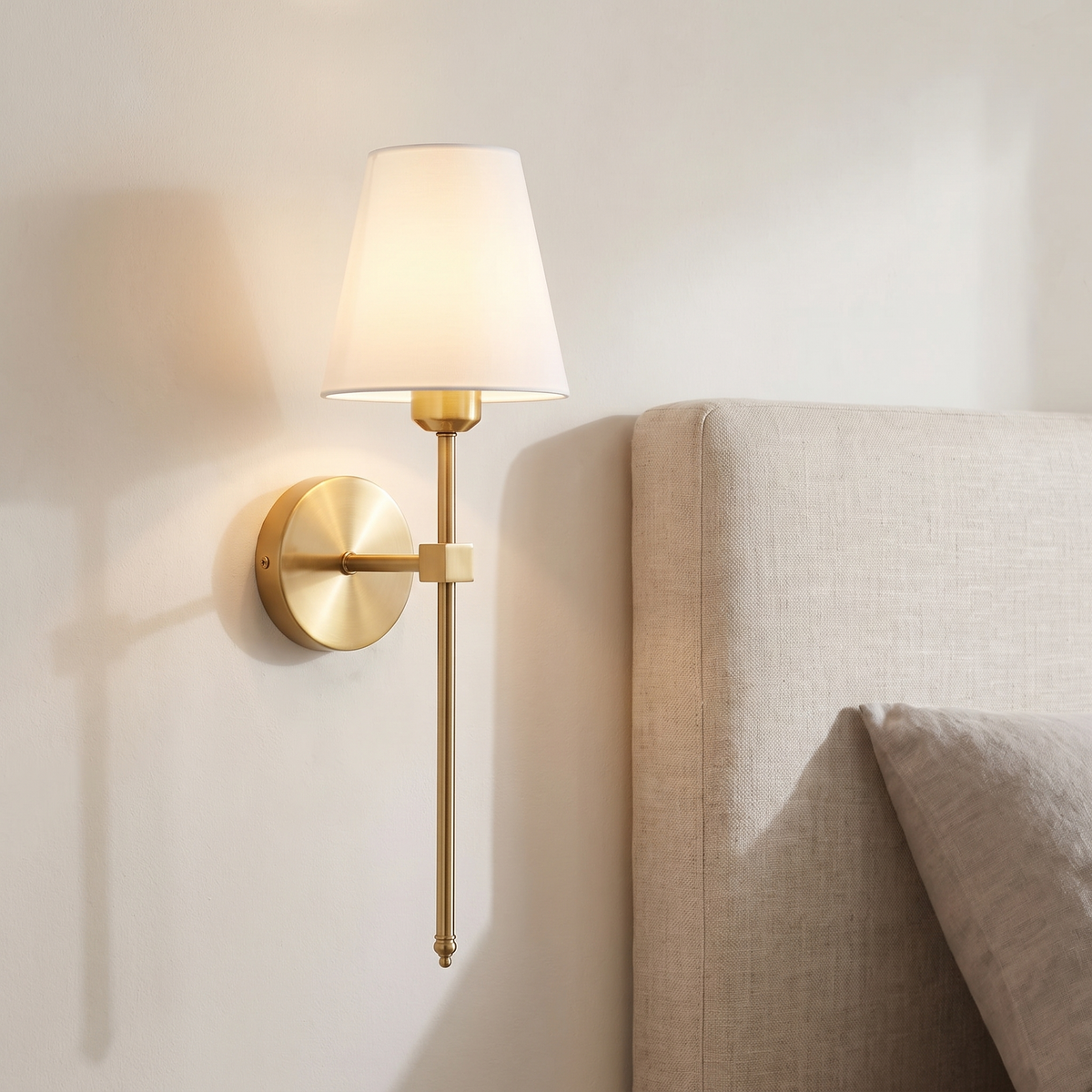 Atelierée Halston rechargeable brass wall light mounted beside a bed