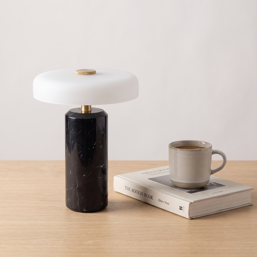 Atelierée Nero black marble table lamp shown beside a book and mug for scale