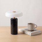 Atelierée Nero black marble table lamp shown beside a book and mug for scale