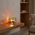 Stained glass book lamp glowing on an oak shelf