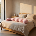 Oversized dinosaur full body plush pillow along a made bed