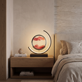 Quicksand rotating LED table lamp lit on an oak bedside table