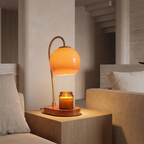 Adjustable candle warmer lamp over a candle on a side table