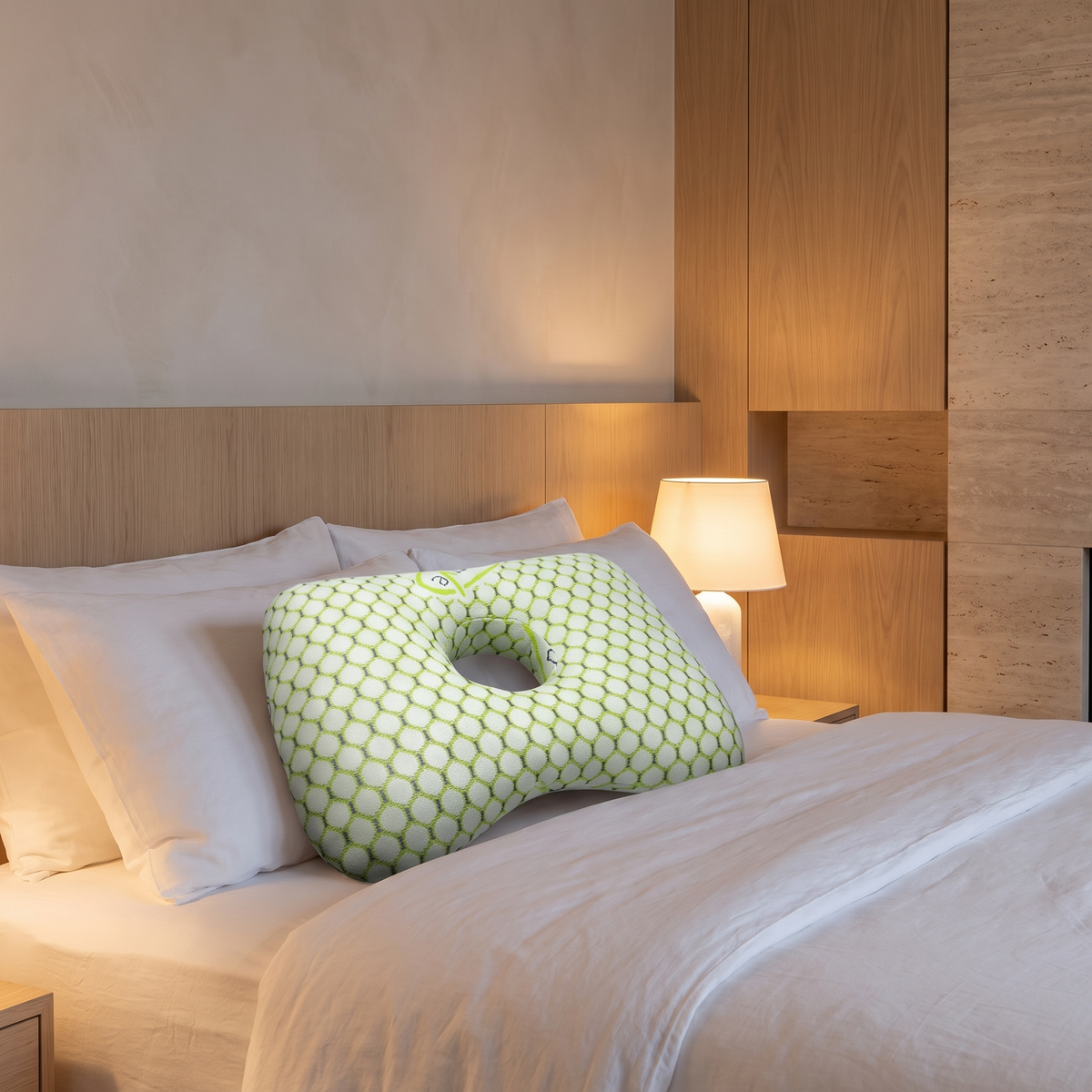Piercing cushion pillow with centre cut out on linen bedding