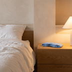 Weighted blackout sleep mask on an oak bedside table