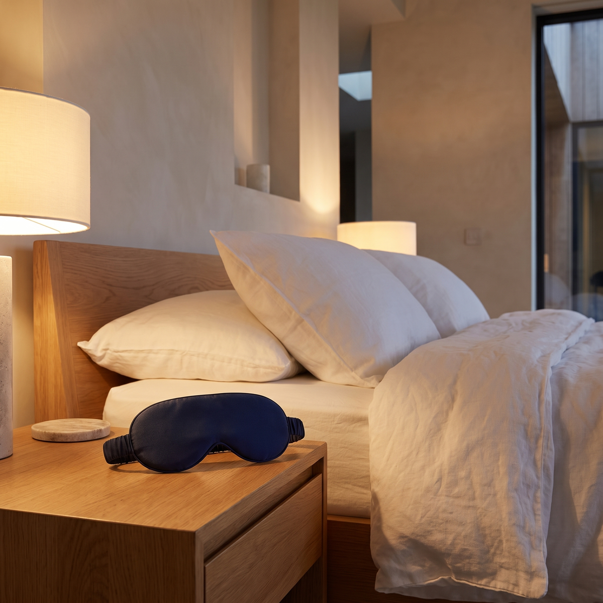 Bamboo contoured blackout sleep mask on an oak bedside table