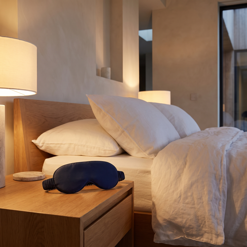 Bamboo contoured blackout sleep mask on an oak bedside table