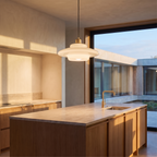 White glass mid century pendant light hanging above a honed stone kitchen island