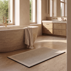 Quick dry absorbent bath mat laid on a honed stone floor beside a freestanding stone bath