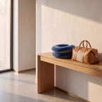 Memory foam chin and neck travel pillow on an oak bench beside a tan leather weekend bag
