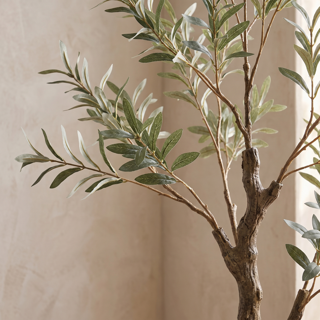 Close detail of the silvered leaves and woody trunk of an artificial olive tree