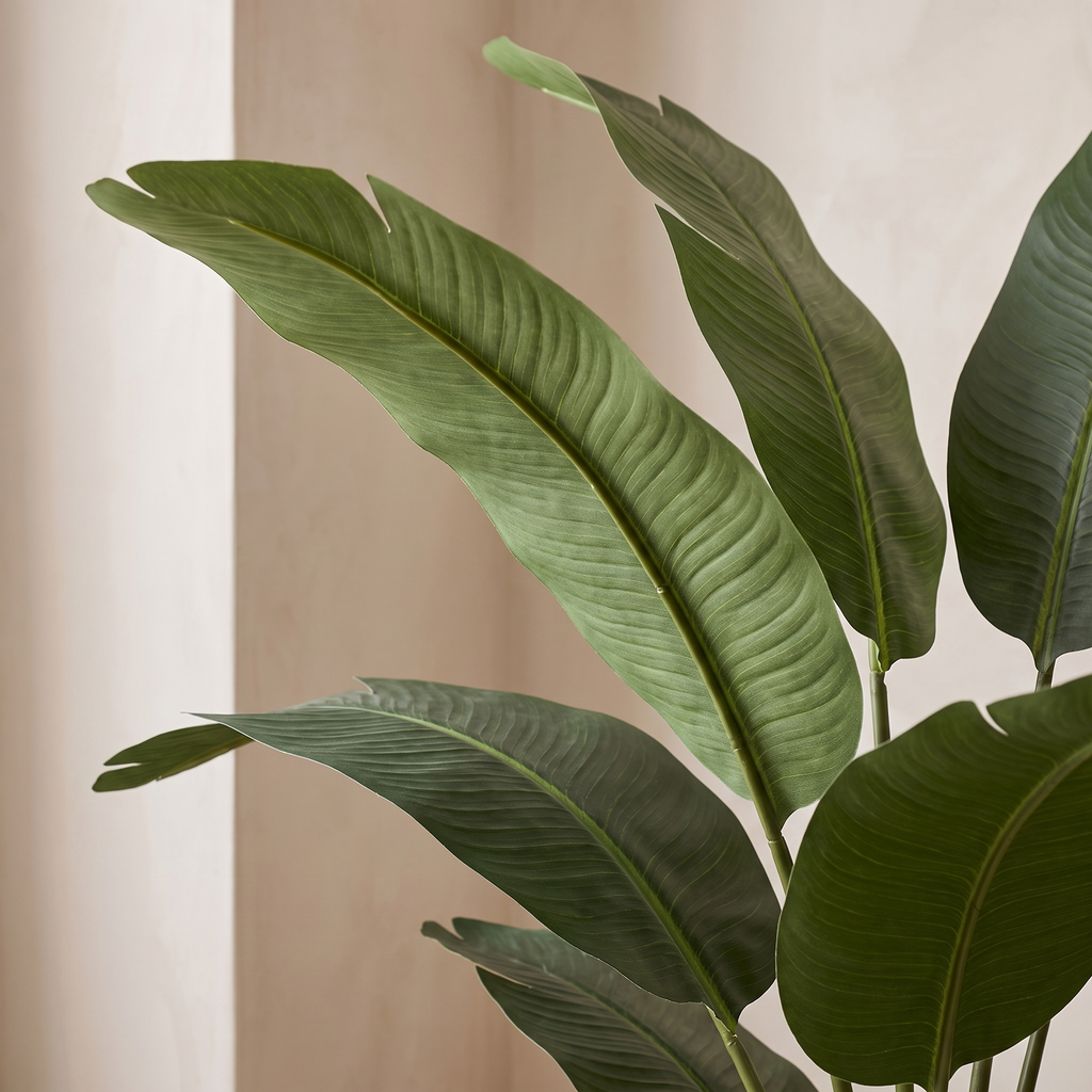 Close detail of a broad arching artificial banana leaf
