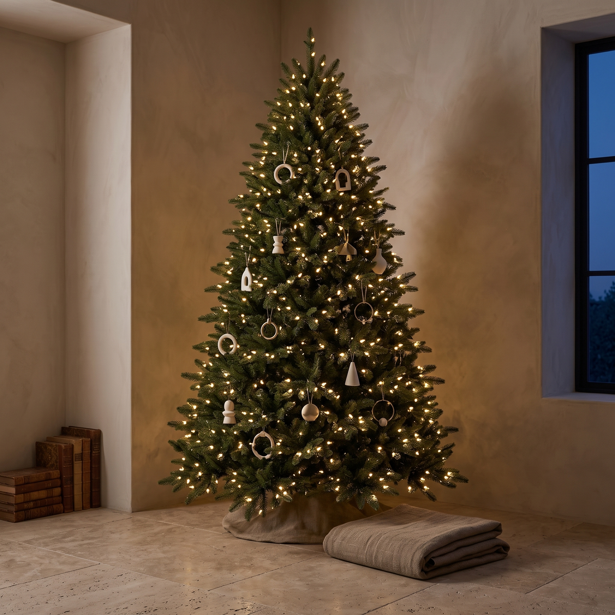 Pre lit artificial Christmas tree glowing in a neutral room at dusk