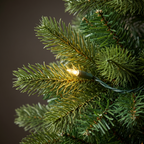 Close detail of Christmas tree branches with a warm white LED among the needles