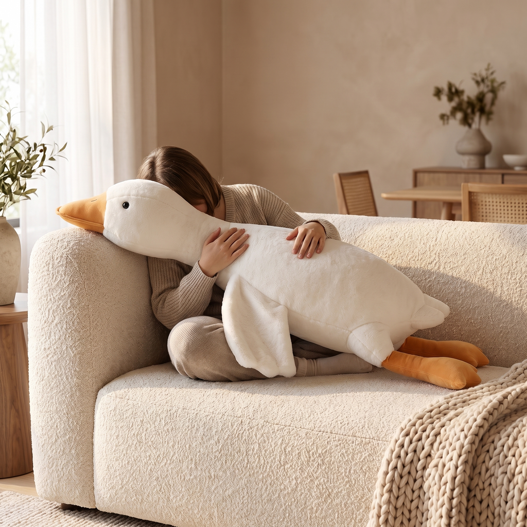 Atelierée long goose plush pillow in use, cuddled on a sofa