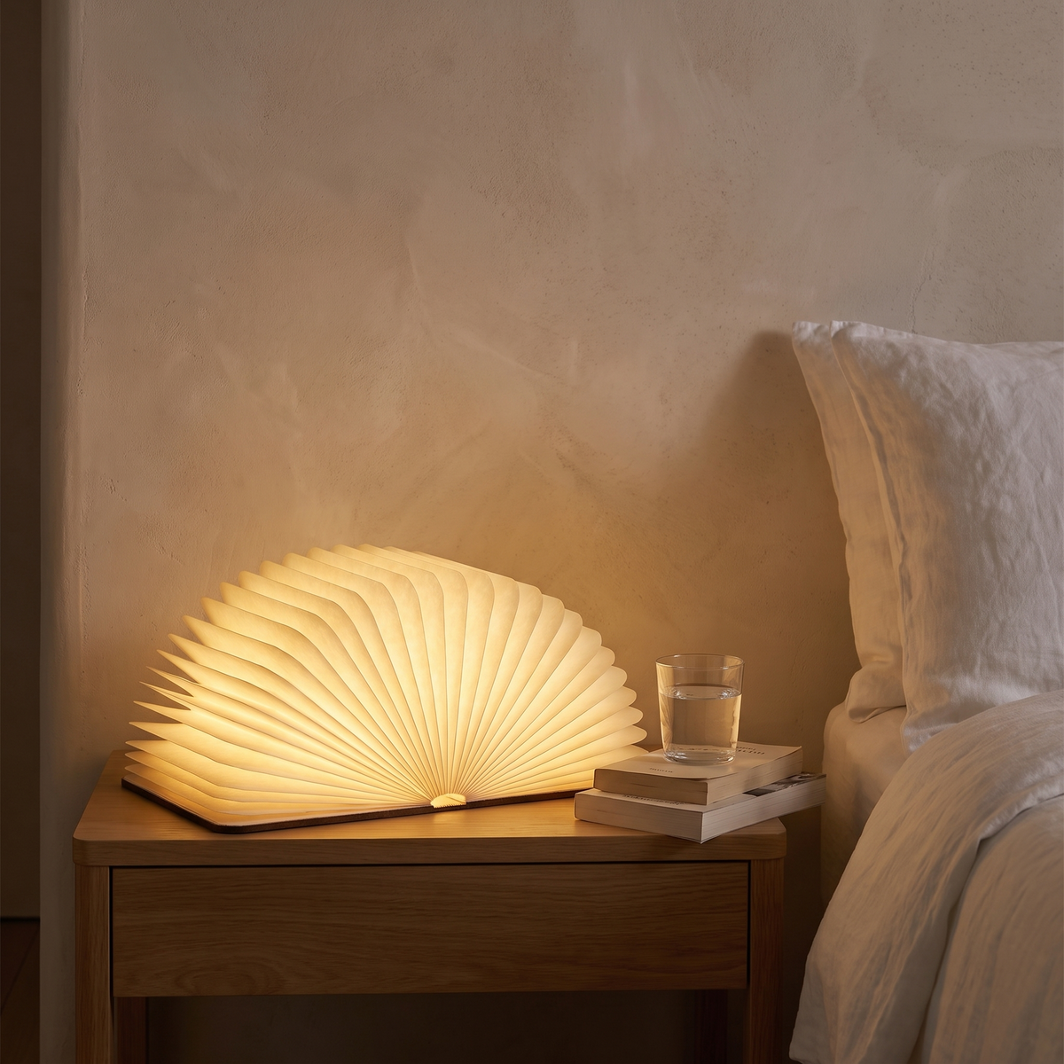 Lumibook foldable table lamp lit on a bedside table