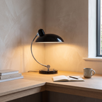 ScandiArc table lamp lit on a home office desk