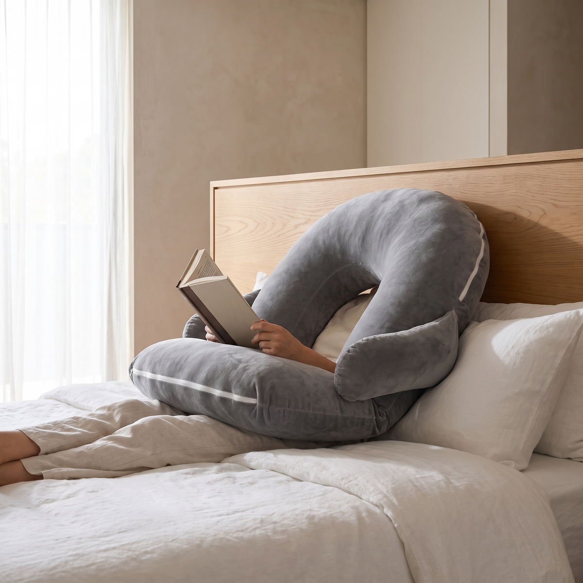 Atelierée adjustable reading pillow in use, sitting up in bed reading