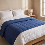 Weighted cooling blanket spread across a made bed