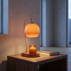 Adjustable candle warmer lamp lit over a candle on a side table