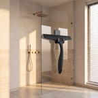 Silicone shower squeegee hanging beside a glass shower screen