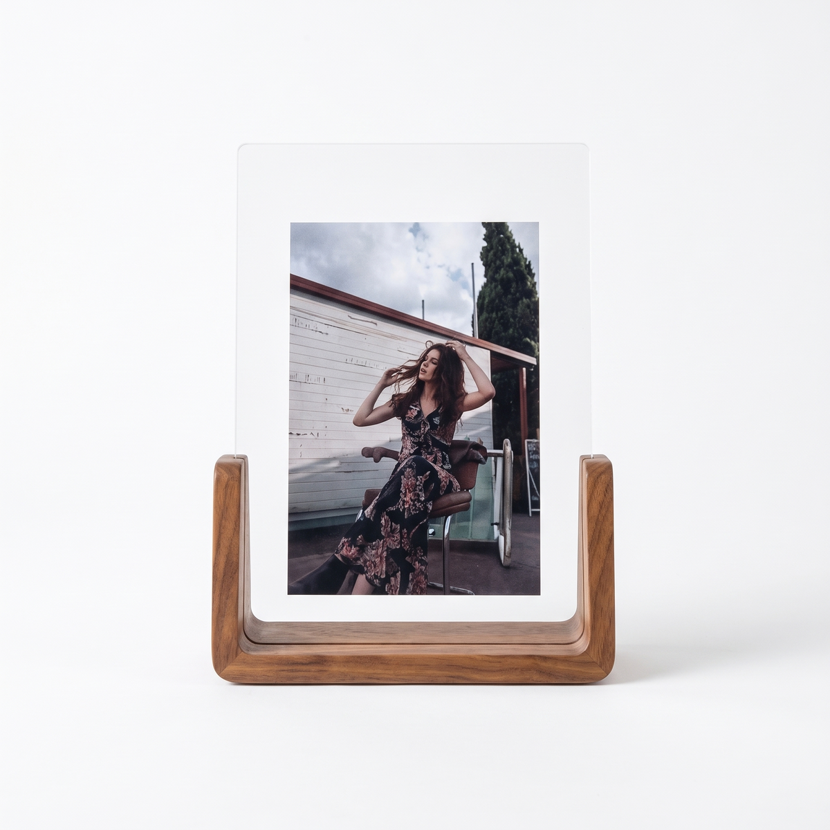 U shaped acrylic and wood photo frame on a plain white background
