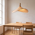 The Vimini pendant lit above a dining table with chairs