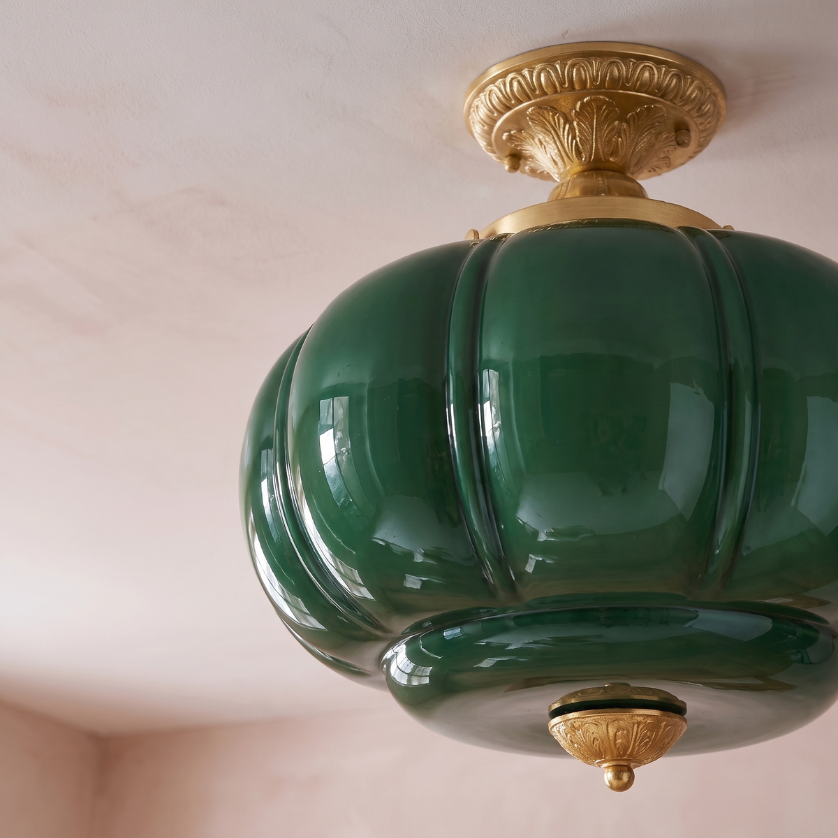 Close detail of the ribbed green glass shade and the cast gold ceiling canopy