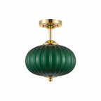 Green glass semi flush ceiling light with gold canopy and finial on a white background