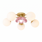 Fleurelle gold six head flush mount ceiling light with white globes and pink petal centre on a white background