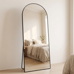 Belvedere arched full length mirror standing in a neutral bedroom